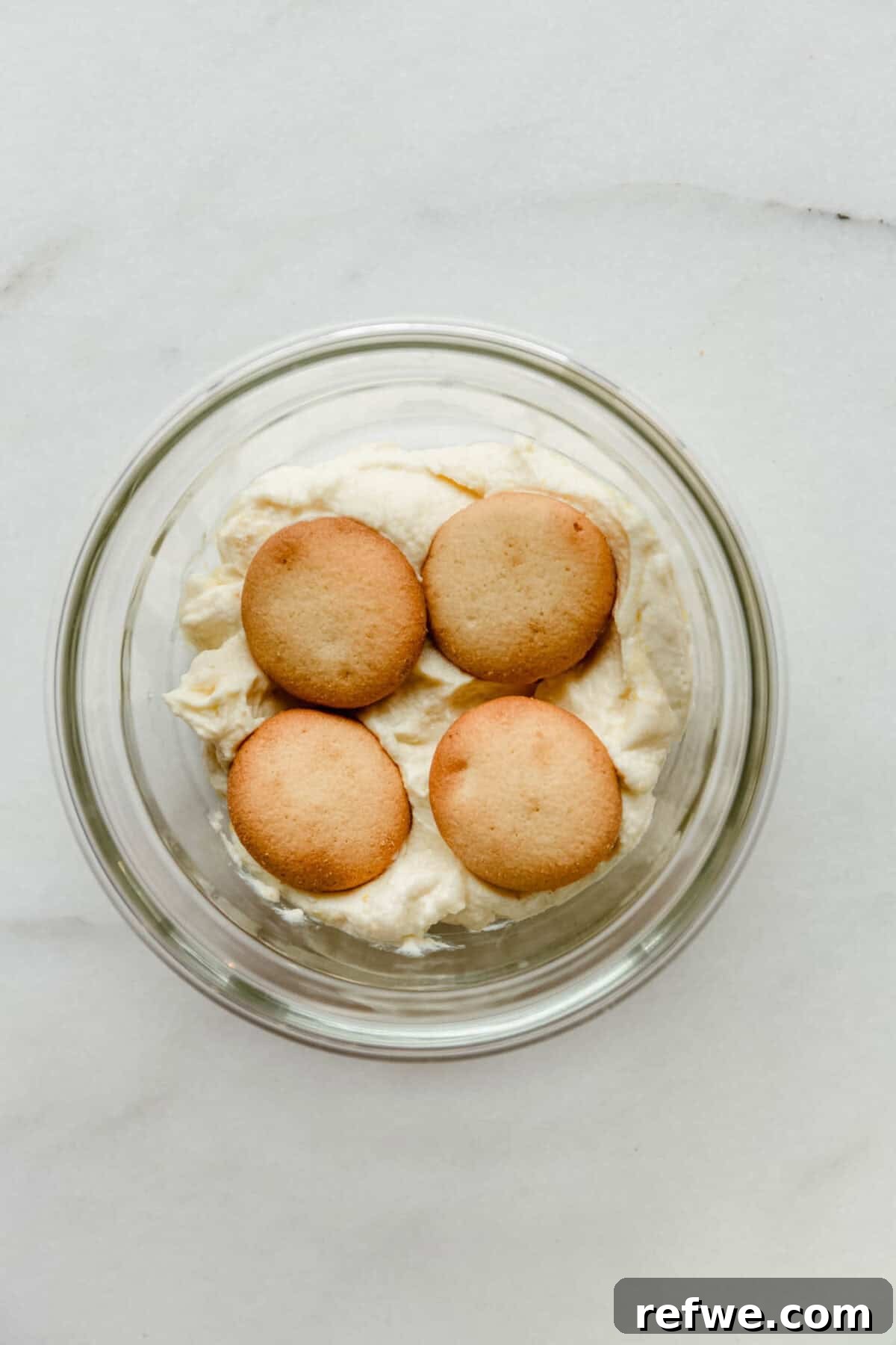 Mini Strawberry Cheesecake Pudding Jars 6 nilla wafers on greek yogurt pudding in a clear container.