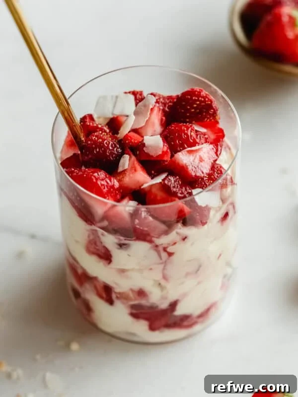 Strawberry pudding jars made with Greek yogurt, Nilla wafers, and vanilla pudding mix with a gold spoon in it.