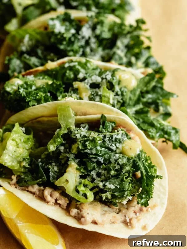 Buffalo Chicken Zucchini Roll-Ups Recipe 15 Close-up of chicken caesar smashed tacos loaded with kale caesar salad and parmesan, served with lemon wedges on kraft paper.