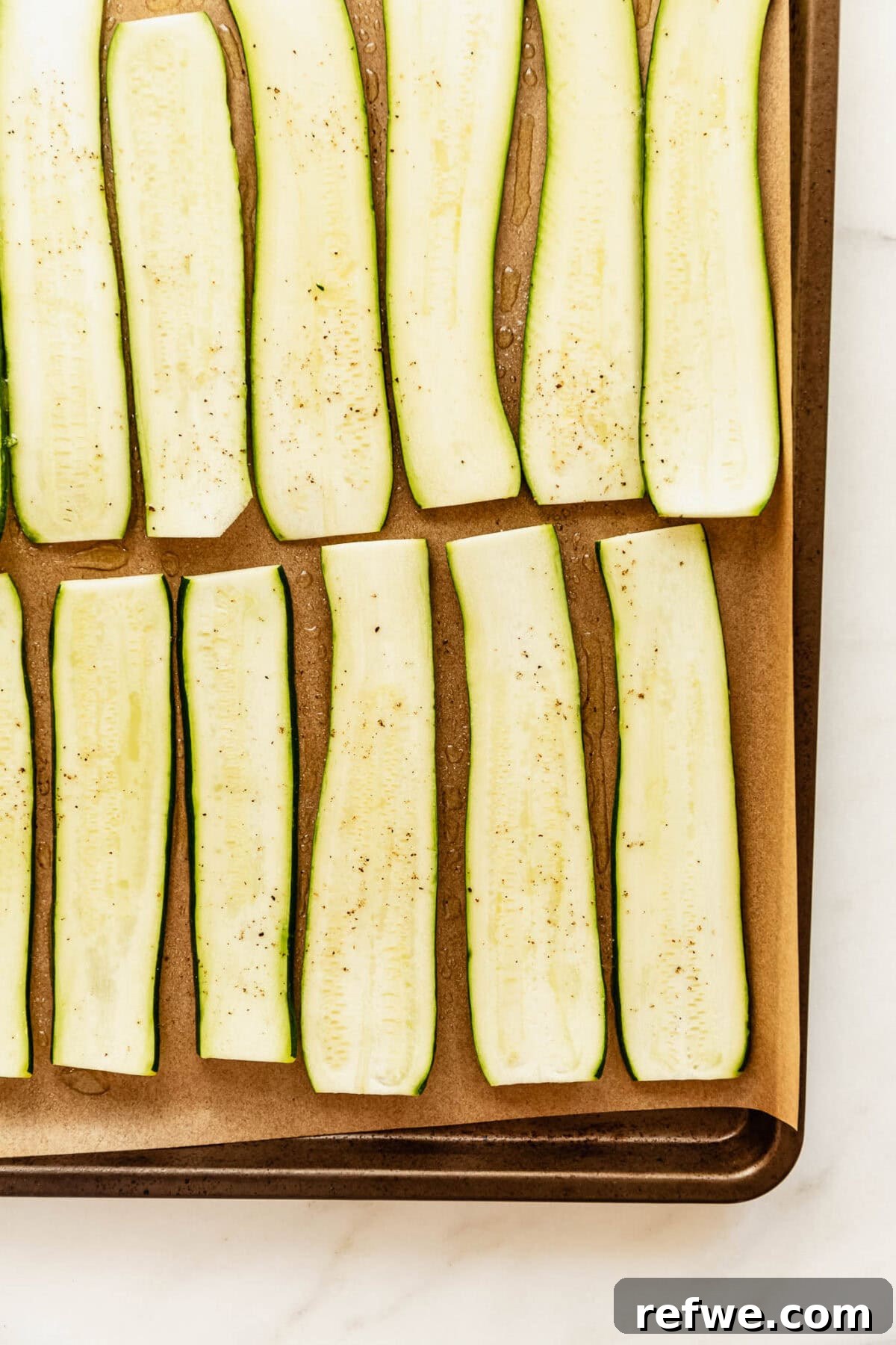 Buffalo Chicken Zucchini Roll-Ups Recipe 4 sliced zucchini on a baking sheet.
