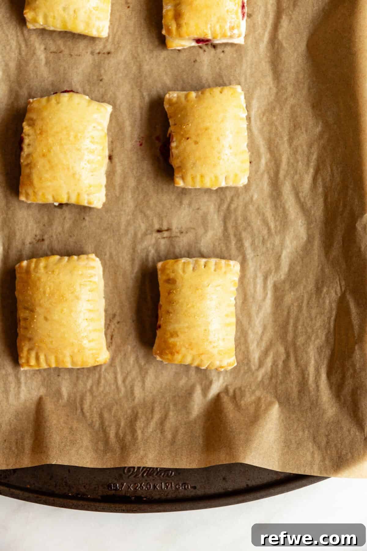Homemade Cottage Cheese Pop Tarts Recipe 11 baked Cottage cheese dough pop tarts on a baking sheet.