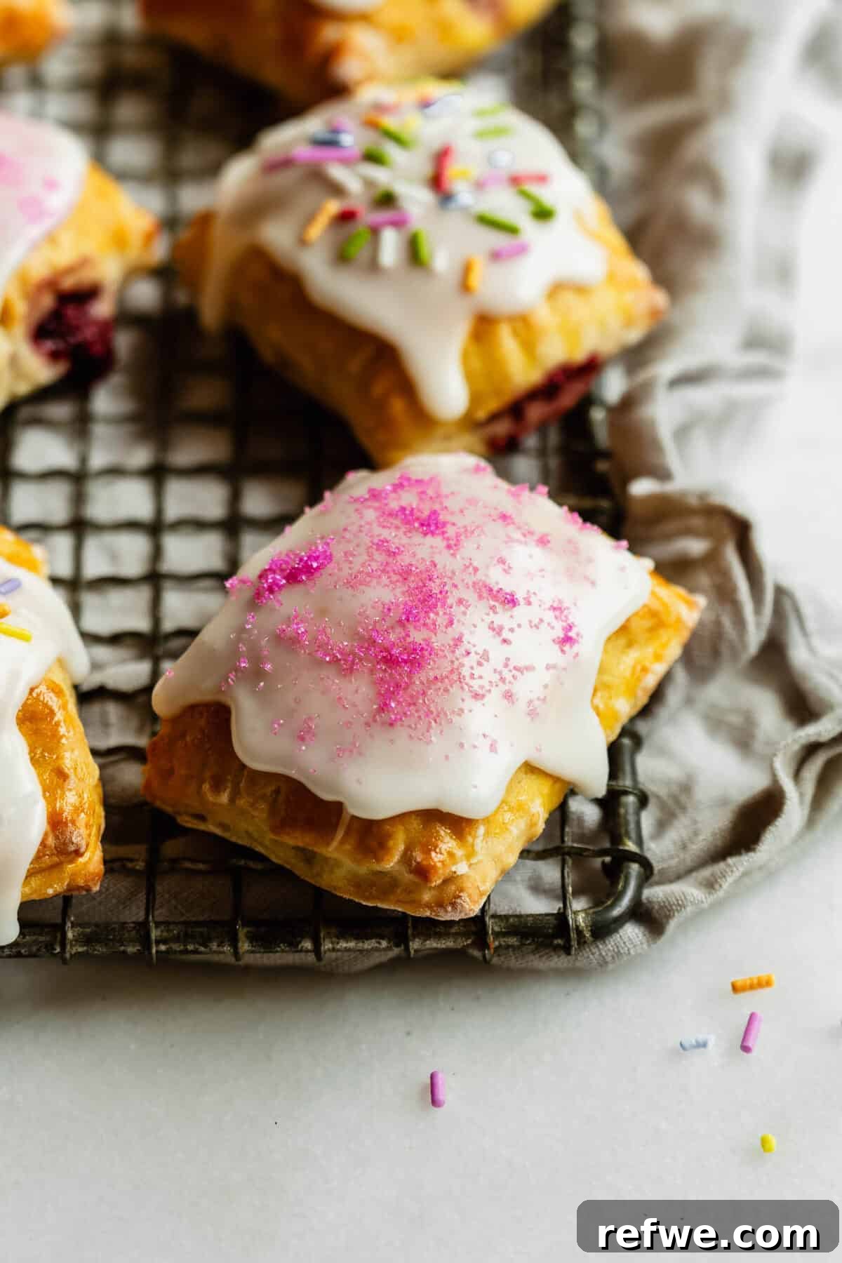 Homemade Cottage Cheese Pop Tarts Recipe 12 Cottage cheese dough pop tarts on a wire rack topped with sprinkles.