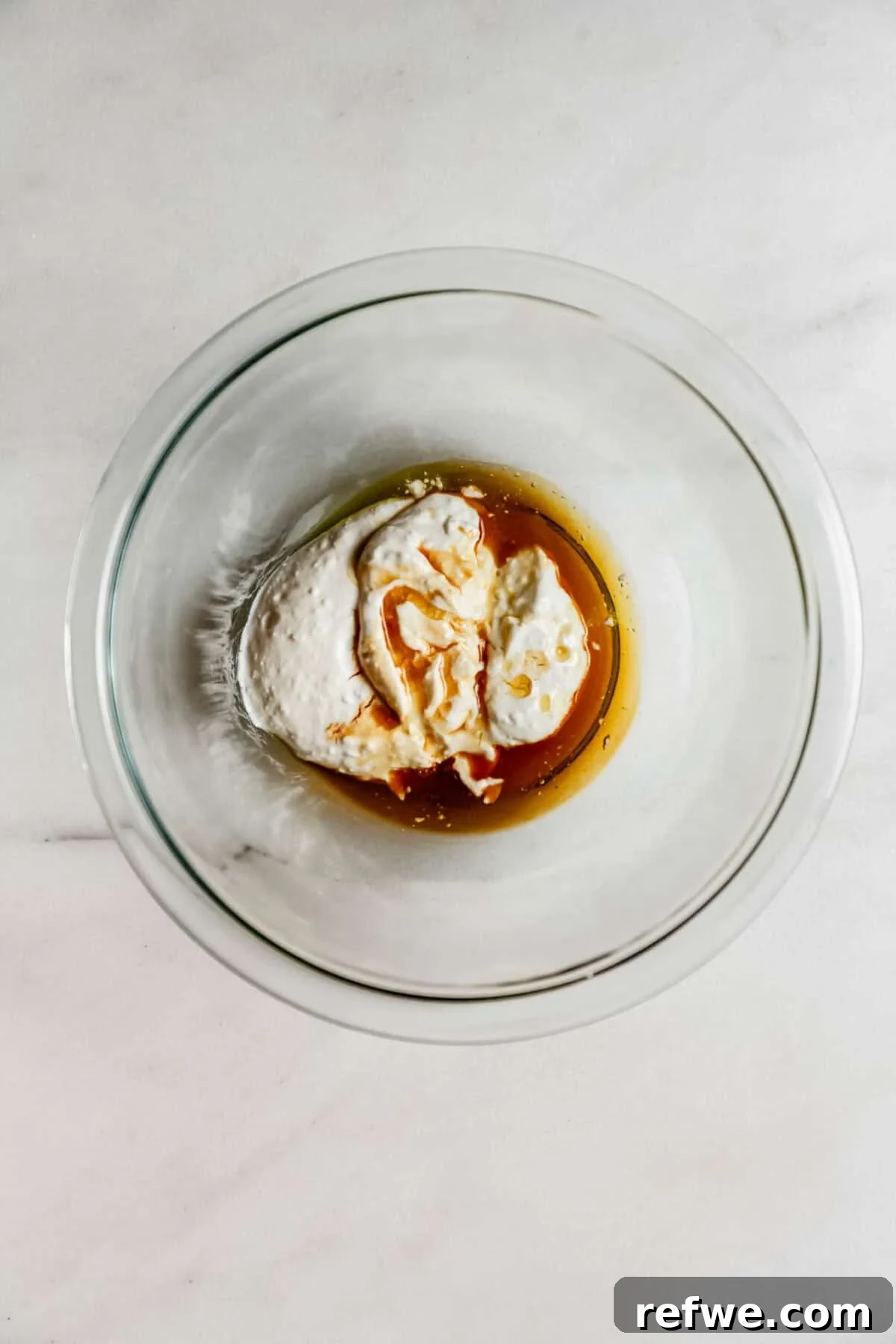 Cottage Cheese Brownie Batter Recipe 5 cottage cheese and maple syrup in a clear mixing bowl.