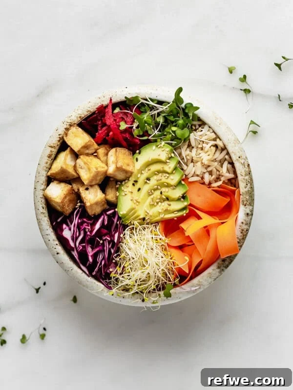 Bang Bang Chicken Bowl Recipe with Spicy Cucumber Salad 12 a ceramic bowl with avocado, veggies, tofu and brown rice