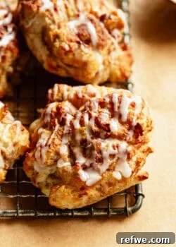 Close-up of glazed cottage cheese apple fritters stacked on a cooling rack.