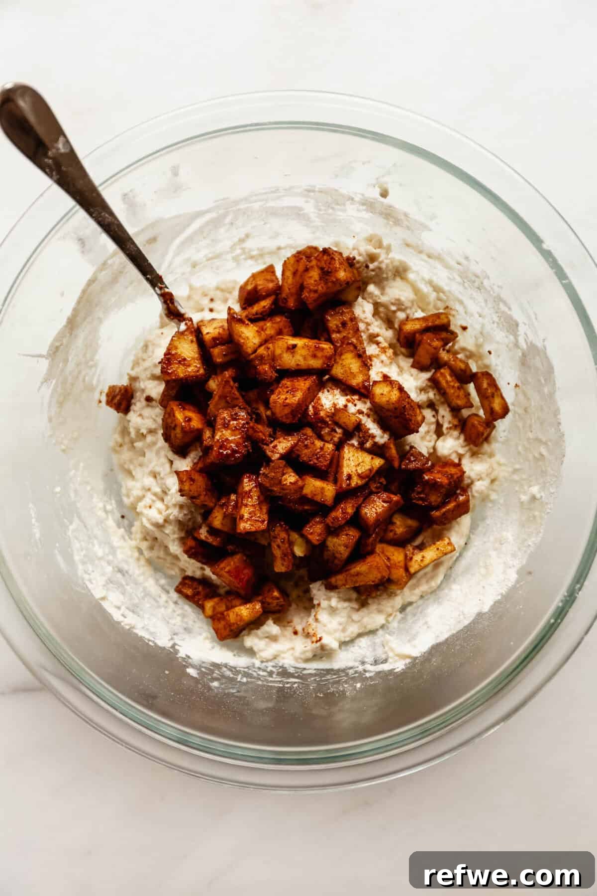 Cottage Cheese Apple Fritters with Maple Cinnamon Glaze 7 Bowl of cottage cheese fritter batter mixed with diced cinnamon apples.