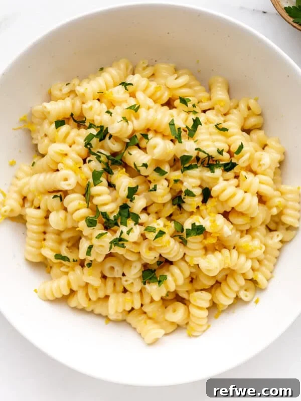 A bowl of lemon fusilli pasta topped with parsley