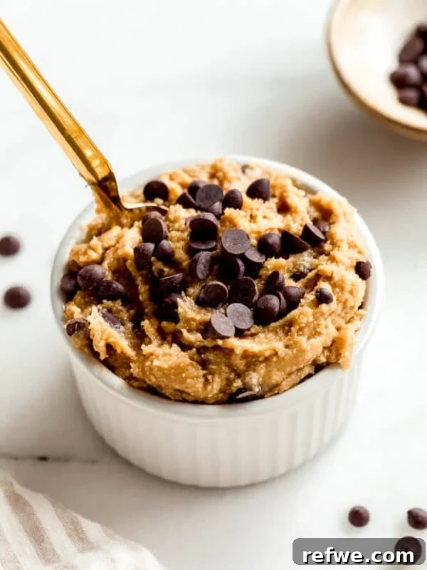 Cottage cheese cookie dough in a white ramekin with a gold spoon in it.