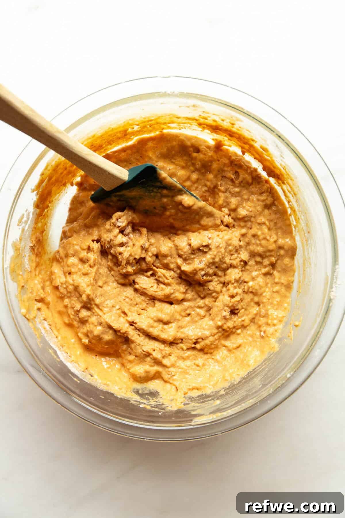 Moist Pumpkin Muffins with Cottage Cheese 7 Cottage cheese pumpkin muffin batter stirred together with a rubber spatula in a glass mixing bowl.